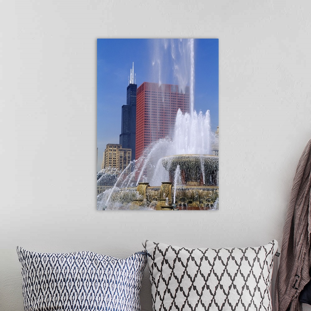 A bohemian room featuring A large fountain shoots water up high with a view of skyscrapers in Chicago shown in the background.