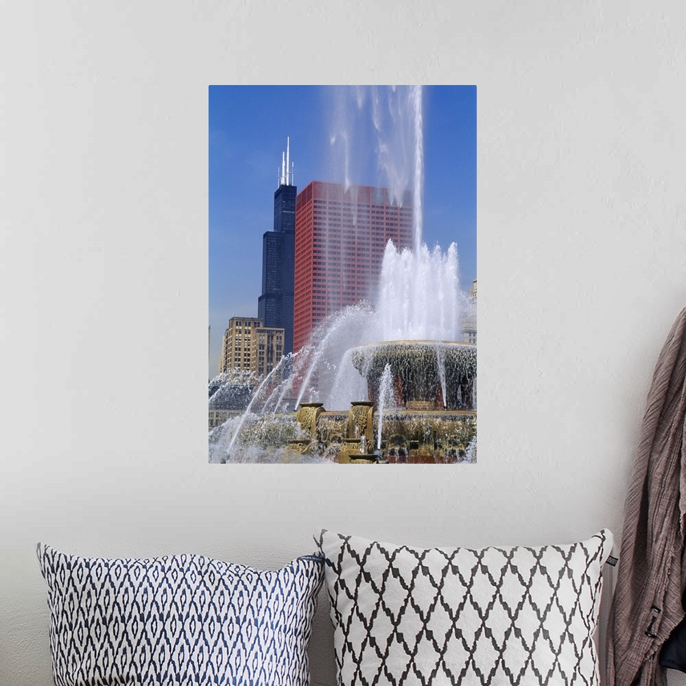 A bohemian room featuring A large fountain shoots water up high with a view of skyscrapers in Chicago shown in the background.