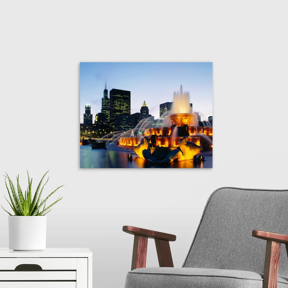 A modern room featuring Huge photograph taken of Buckingham Fountain lit up at night as it sprays water in an artful sequ...