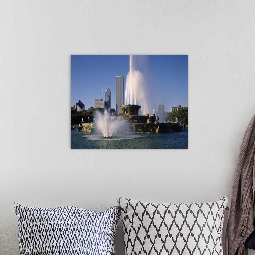 A bohemian room featuring This massive fountain is photographed in front of skyscrapers in the city of Chicago.