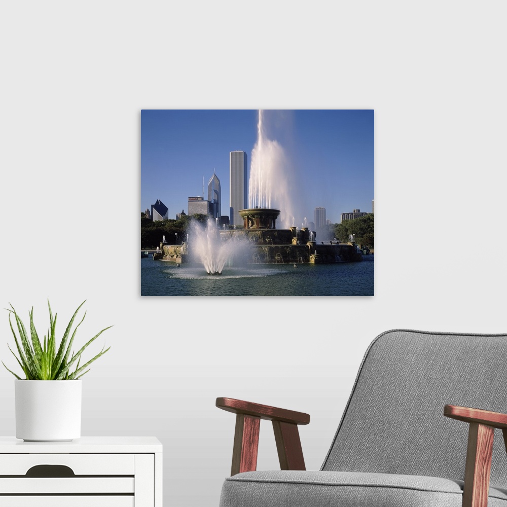 A modern room featuring This massive fountain is photographed in front of skyscrapers in the city of Chicago.