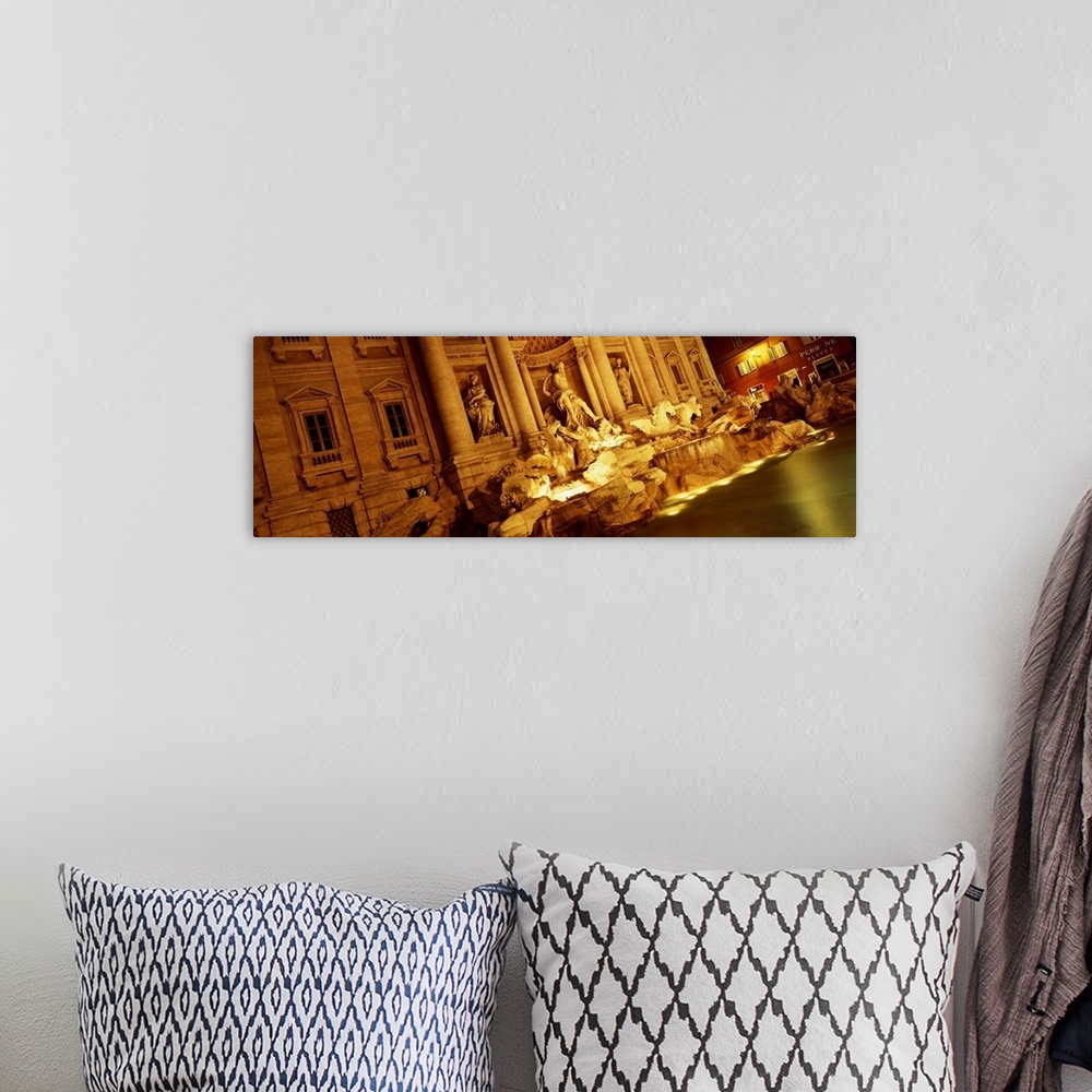 A bohemian room featuring Panoramic canvas photo of Roman statues that are bathed in light at night.