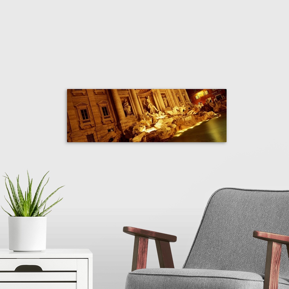 A modern room featuring Panoramic canvas photo of Roman statues that are bathed in light at night.