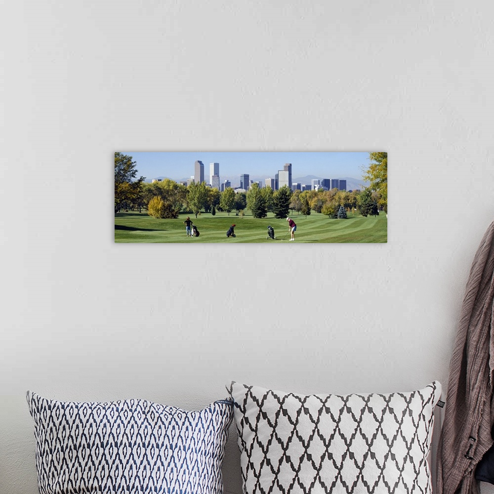 A bohemian room featuring Four people playing golf with buildings in the background, Denver, Colorado