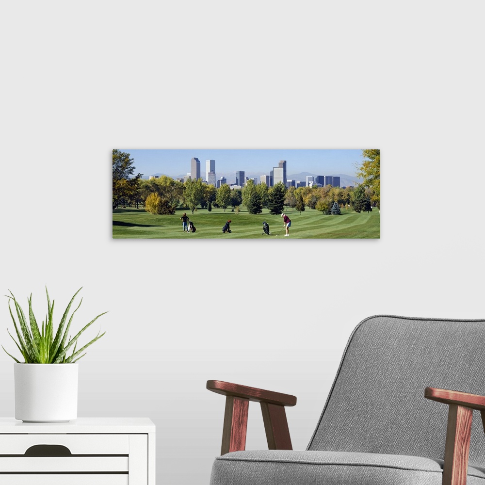 A modern room featuring Four people playing golf with buildings in the background, Denver, Colorado