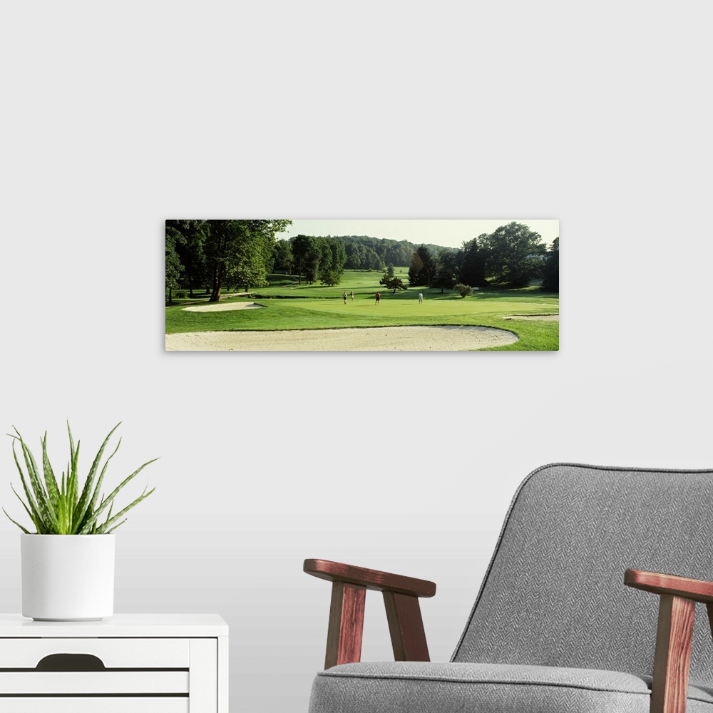 A modern room featuring Four people playing on a golf course, Baltimore County, Maryland