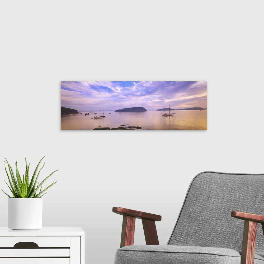 A modern room featuring Landscape photograph of numerous small boats in Frenchman Bay beneath a vibrant sky of wispy clou...