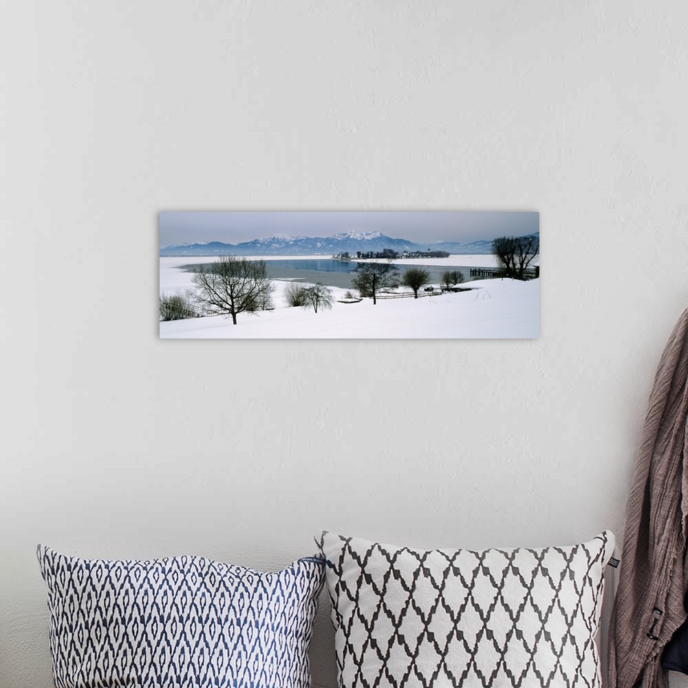 A bohemian room featuring Frozen lake in front of snowcapped mountains, Chiemsee, Bavaria, Germany