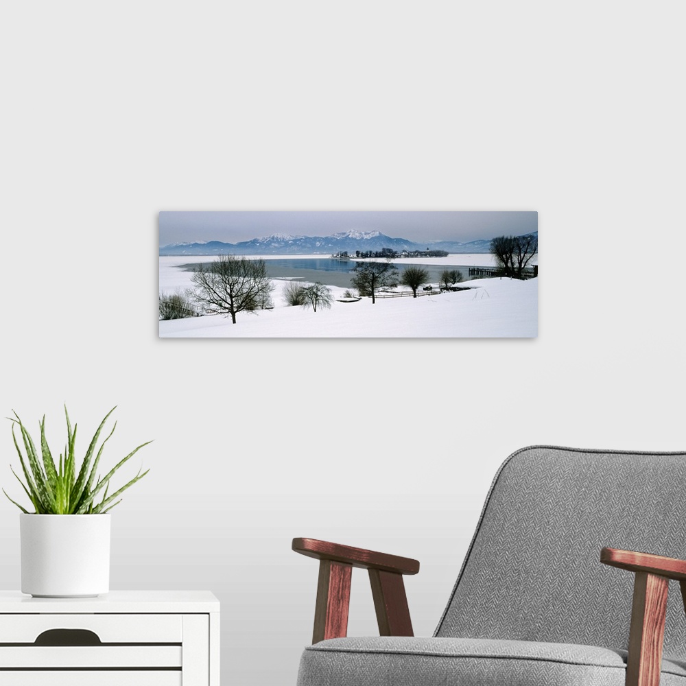 A modern room featuring Frozen lake in front of snowcapped mountains, Chiemsee, Bavaria, Germany