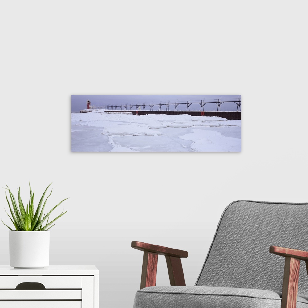 A modern room featuring Panoramic photograph of pier stretching into ice covered river leading to a tower with a guiding ...