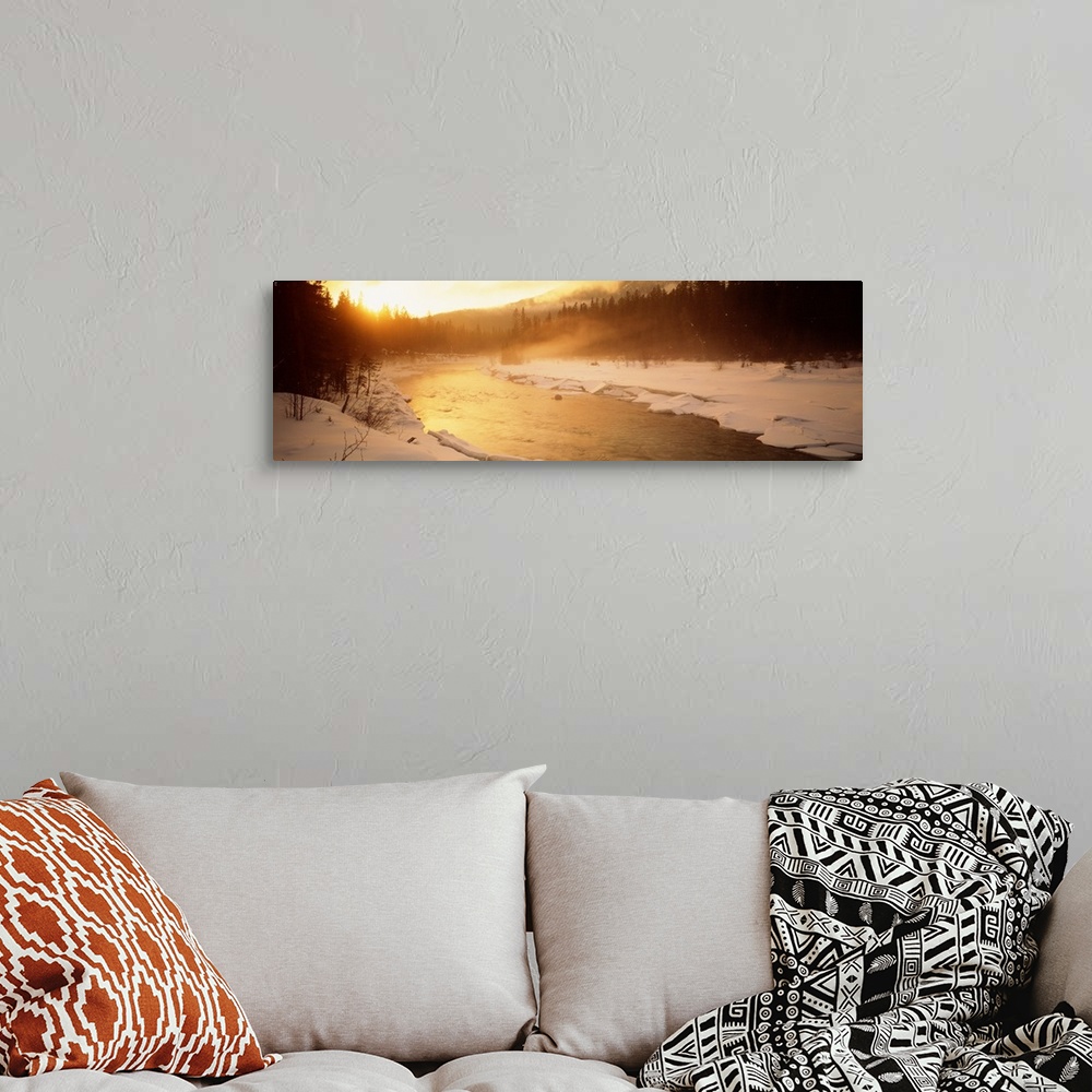 A bohemian room featuring Panoramic image of a river running through a frozen landscape with fog coming off it and warm sun...