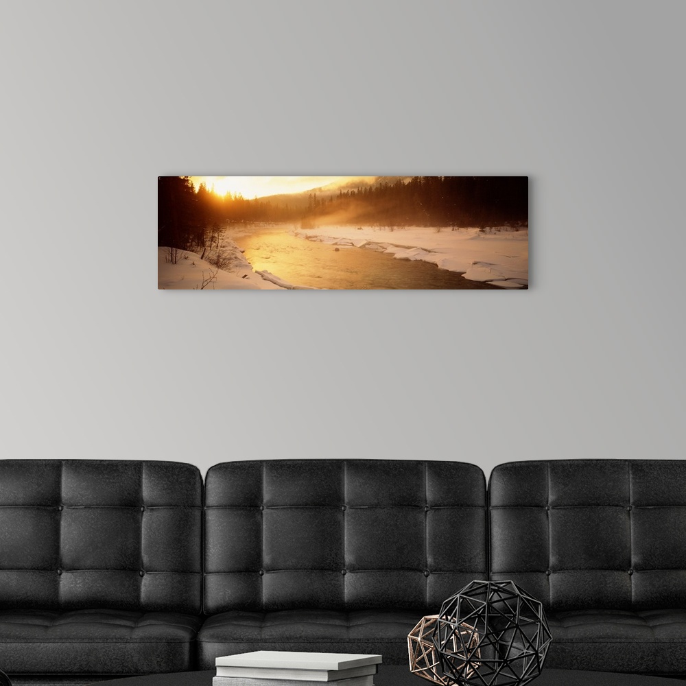 A modern room featuring Panoramic image of a river running through a frozen landscape with fog coming off it and warm sun...