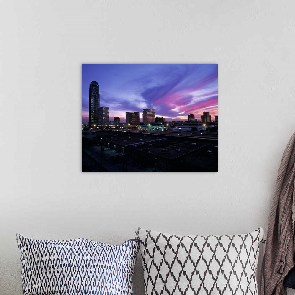 A bohemian room featuring These clouds are a colorful swirl across the sky at sunset over city skyscrapers and shopping cen...