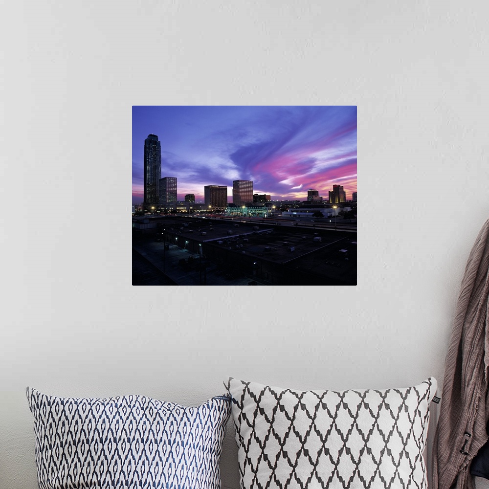 A bohemian room featuring These clouds are a colorful swirl across the sky at sunset over city skyscrapers and shopping cen...