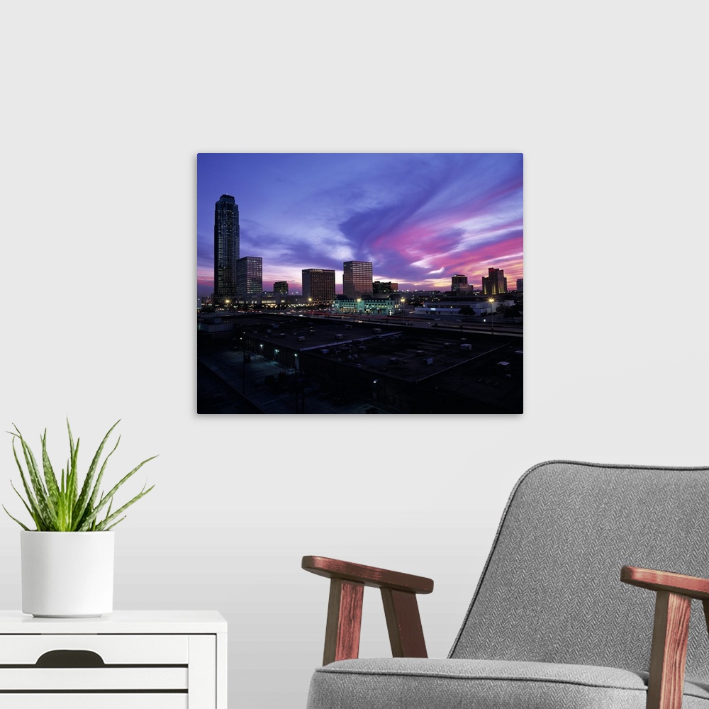 A modern room featuring These clouds are a colorful swirl across the sky at sunset over city skyscrapers and shopping cen...