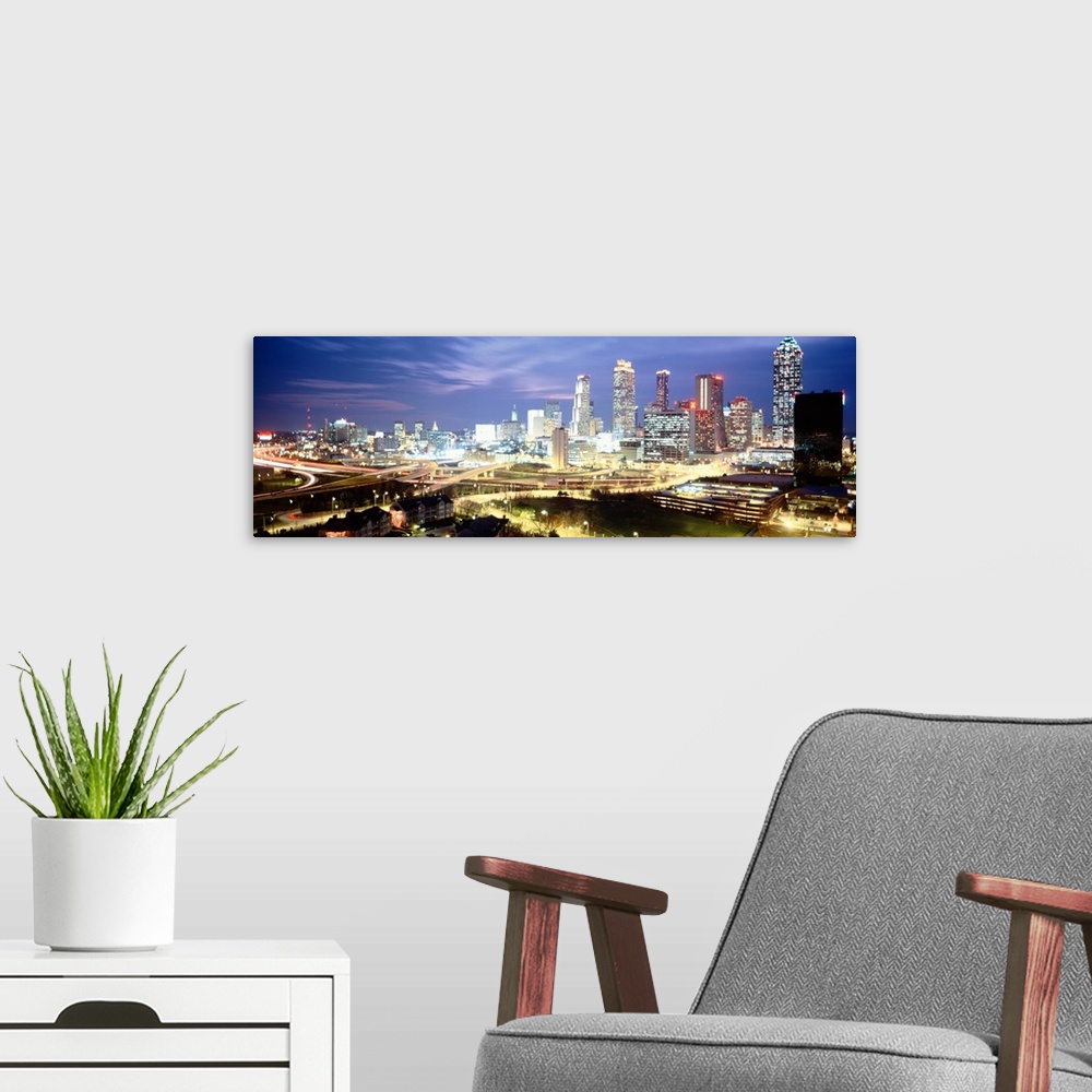 A modern room featuring Panoramic photograph of buildings lit up against a dusk sky.