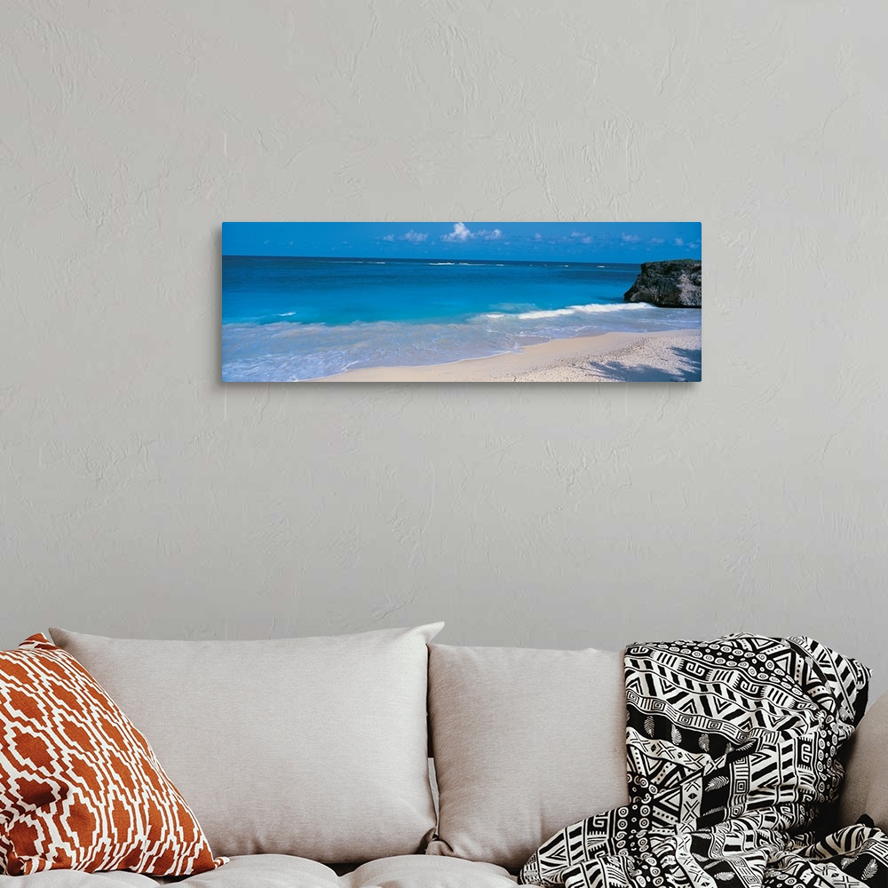 A bohemian room featuring This is a panoramic photograph of small waves breaking on a sandy tropical beach.