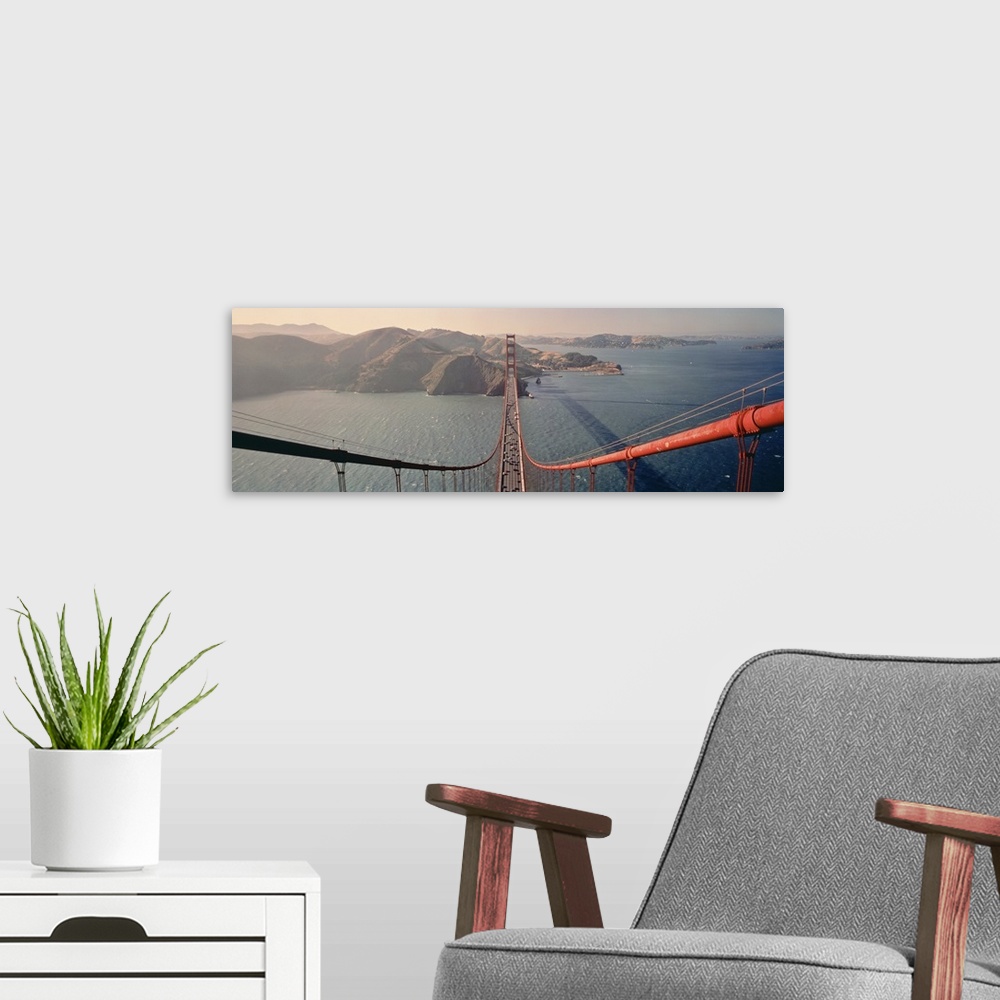 A modern room featuring A wide angle photograph taken from on top of the golden gate bridge while looking down the cables...