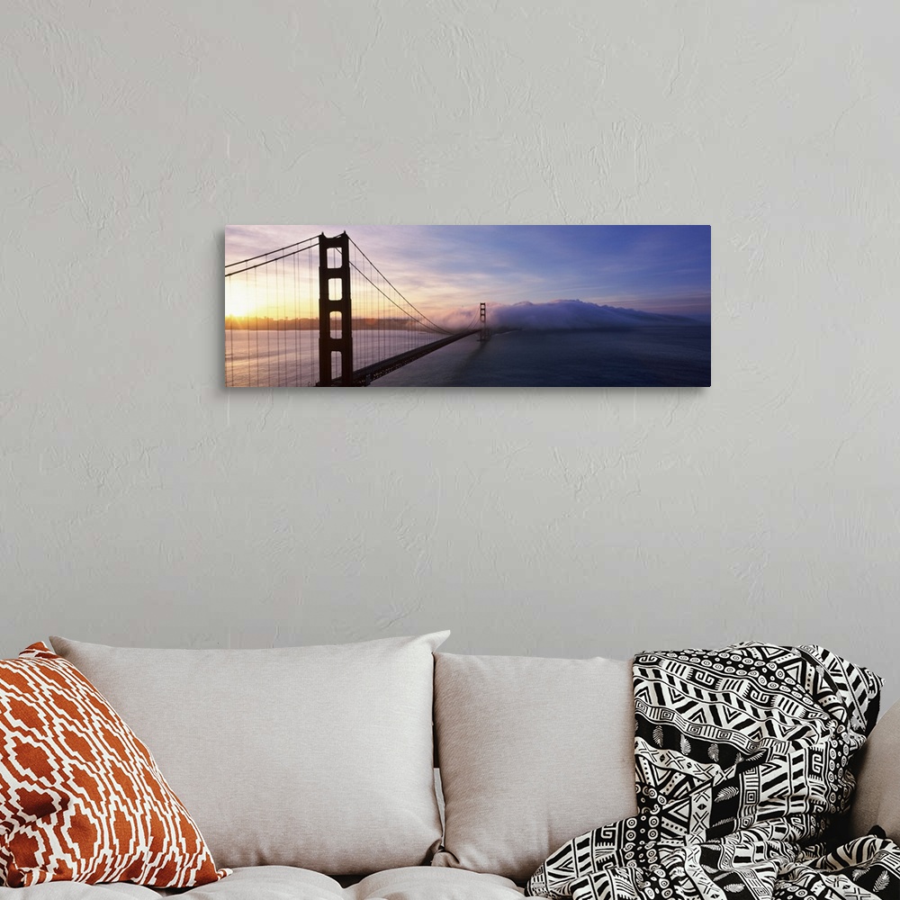 A bohemian room featuring The Golden Gate Bridge is photographed in panoramic view looking from one end down to the other w...