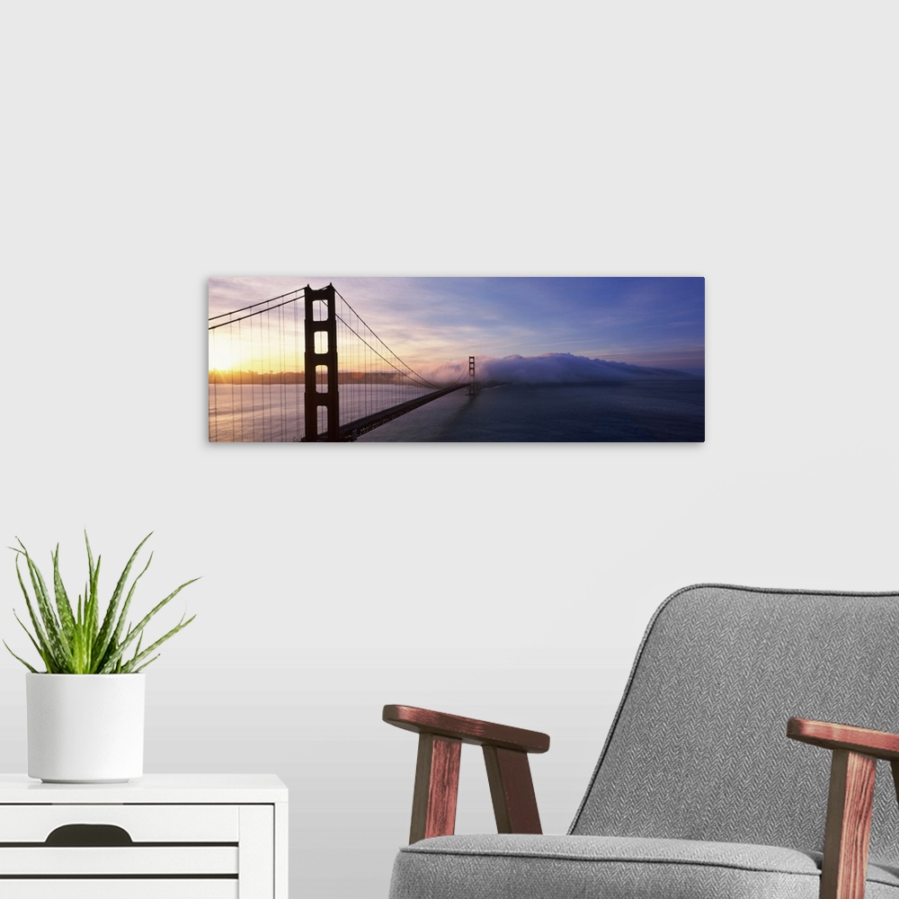 A modern room featuring The Golden Gate Bridge is photographed in panoramic view looking from one end down to the other w...