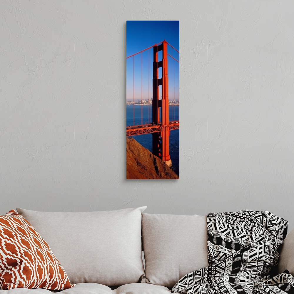 A bohemian room featuring Tall panoramic photo of on of the main portions of the Golden Gate Bridge with cars driving acros...