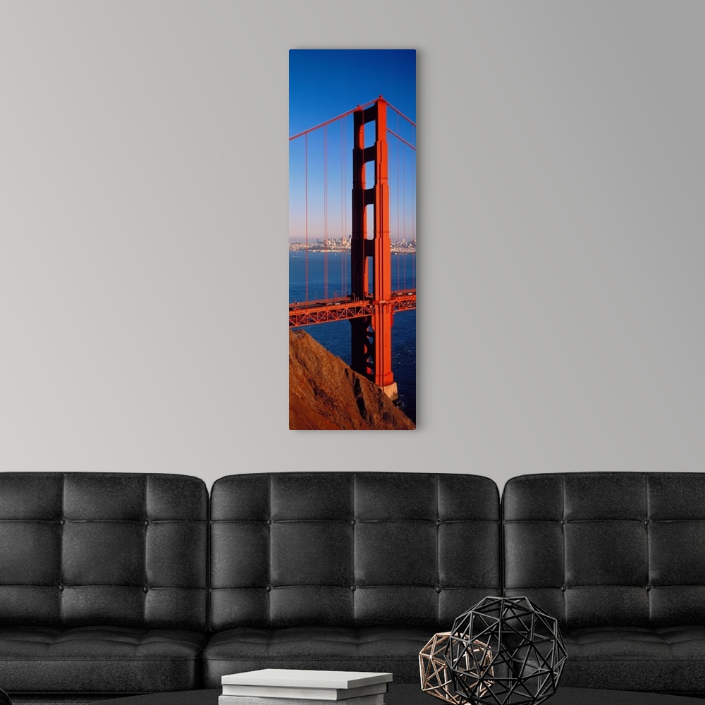 A modern room featuring Tall panoramic photo of on of the main portions of the Golden Gate Bridge with cars driving acros...