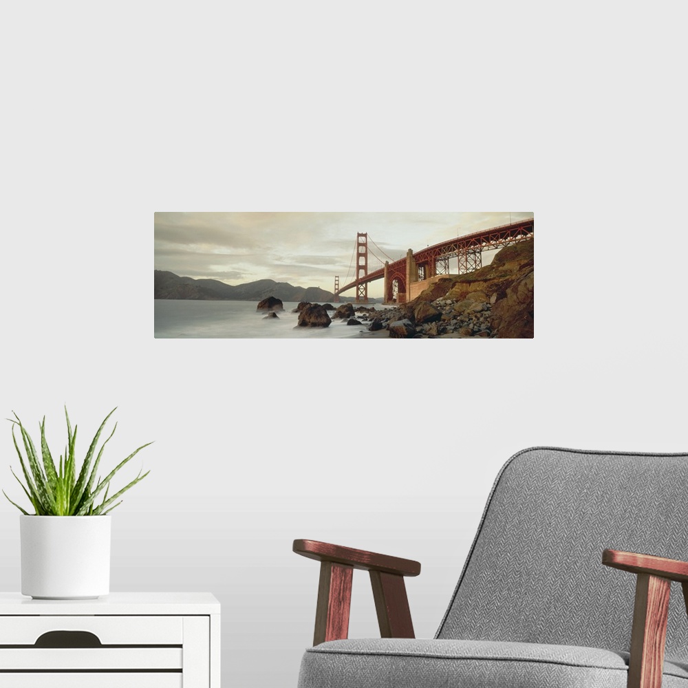A modern room featuring Panoramic photograph shows a body of water slowly crashing into the rocky shores that sit next to...