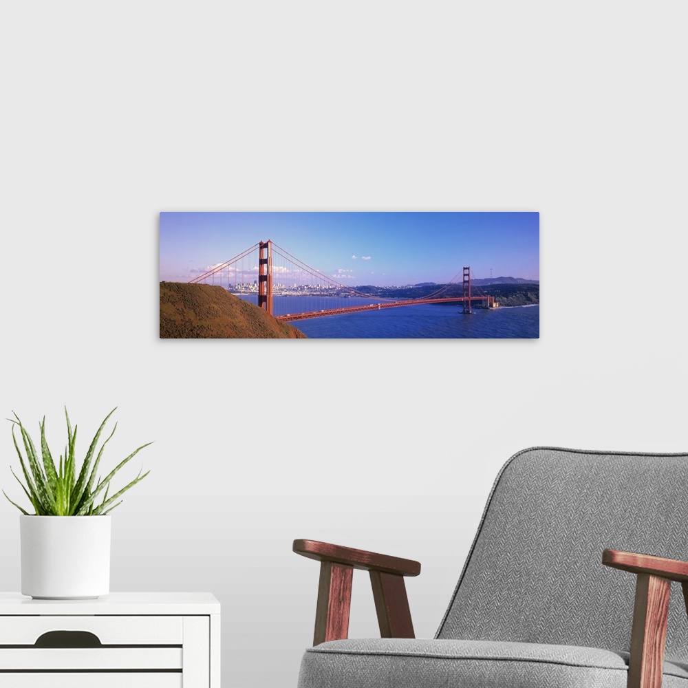 A modern room featuring Panoramic photo on canvas of the Golden Gate Bridge spanning from left to right with the city in ...