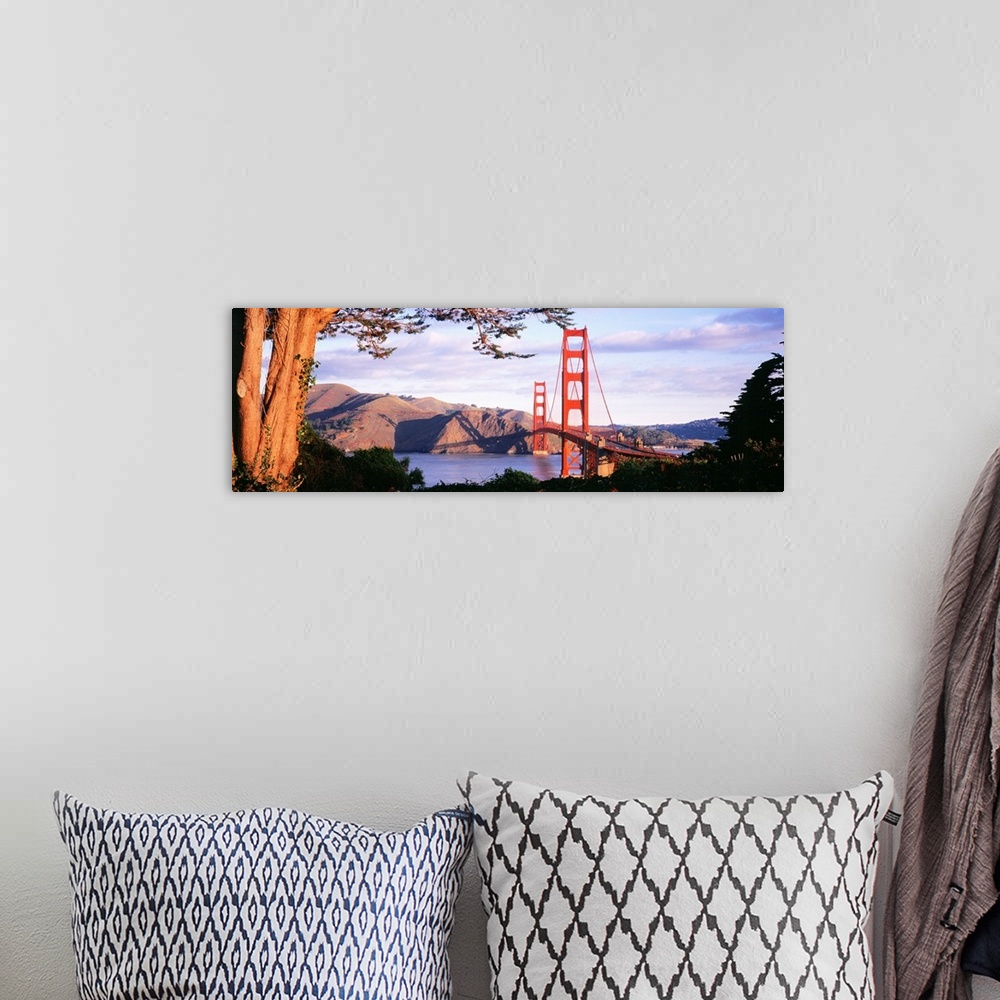 A bohemian room featuring This panoramic photograph shows a view of the suspension bridge and harbor through a park filled ...