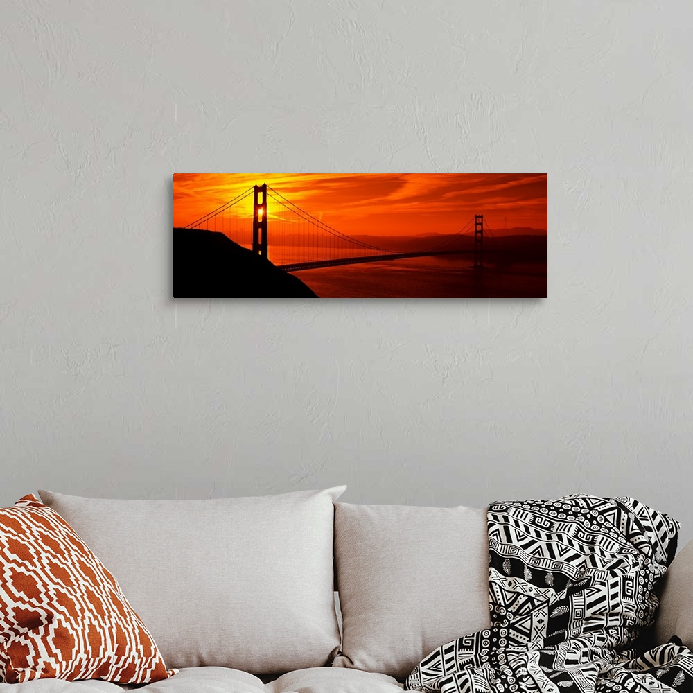 A bohemian room featuring This oversized wall art is a panorama of San Francisco Bay at sunset where the suspension bridge ...