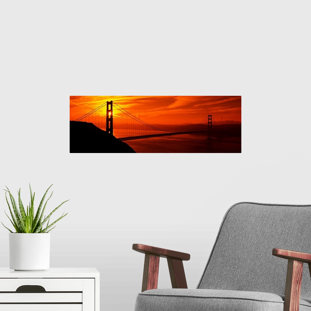 A modern room featuring This oversized wall art is a panorama of San Francisco Bay at sunset where the suspension bridge ...