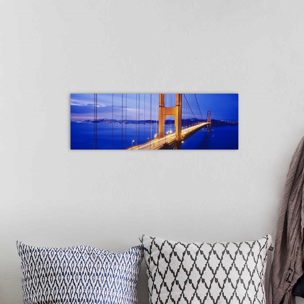 A bohemian room featuring Long and narrow photo print of an up close view of the Golden Gate Bridge lit up at night with ca...