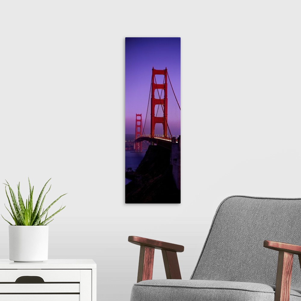 A modern room featuring Oversized, vertical photograph taken at an angle of the Golden Gate Bridge at dusk, in San Franci...