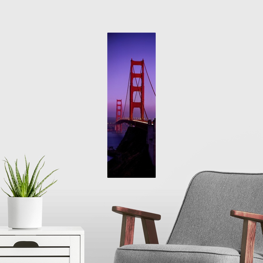 A modern room featuring Oversized, vertical photograph taken at an angle of the Golden Gate Bridge at dusk, in San Franci...