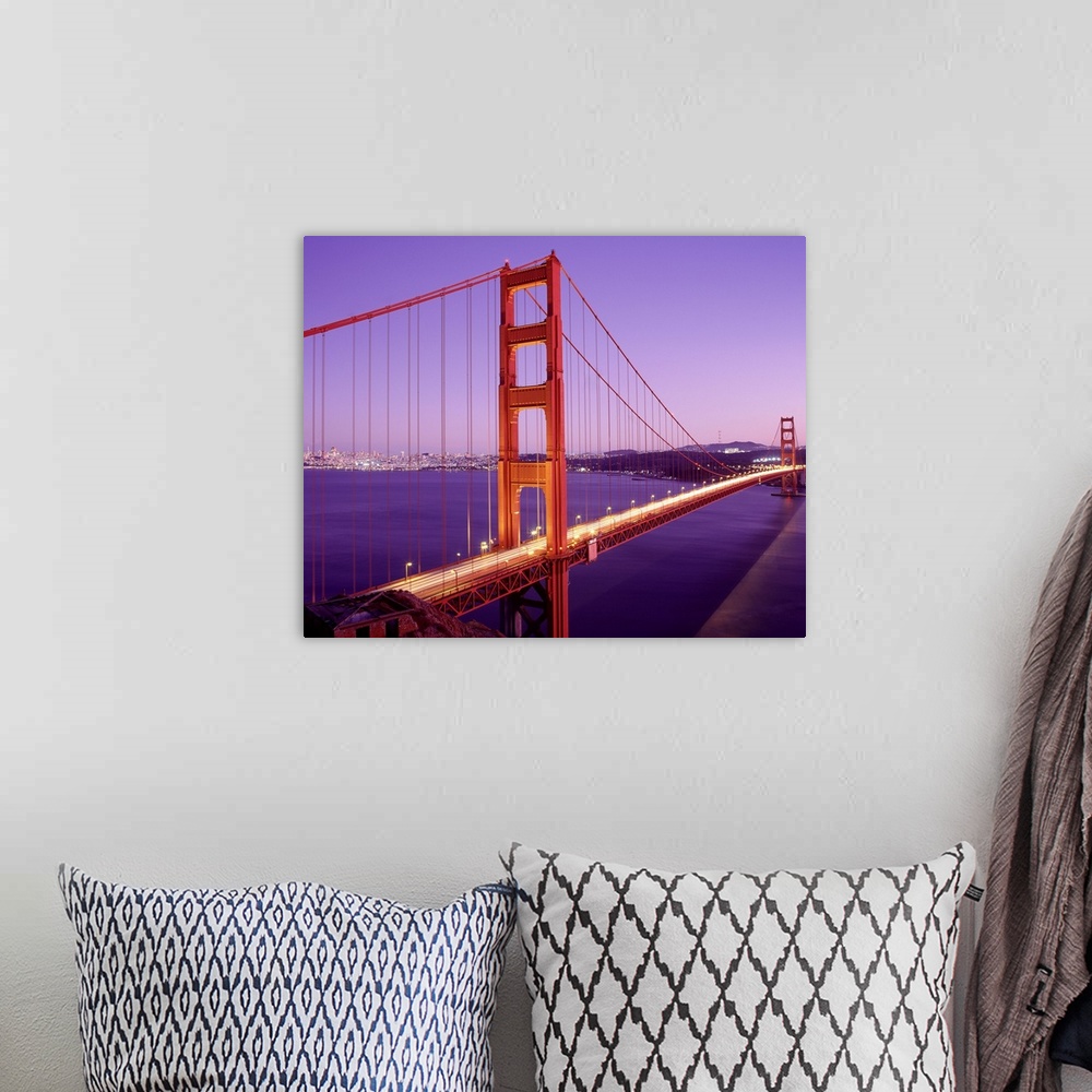 A bohemian room featuring Cars driver over the Golden Gate Bridge in San Francisco as the setting sun creates purple hues i...