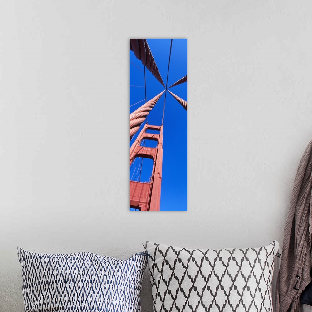 A bohemian room featuring Up-close vertical panoramic photograph of bridge spire and cables under a clear sky.