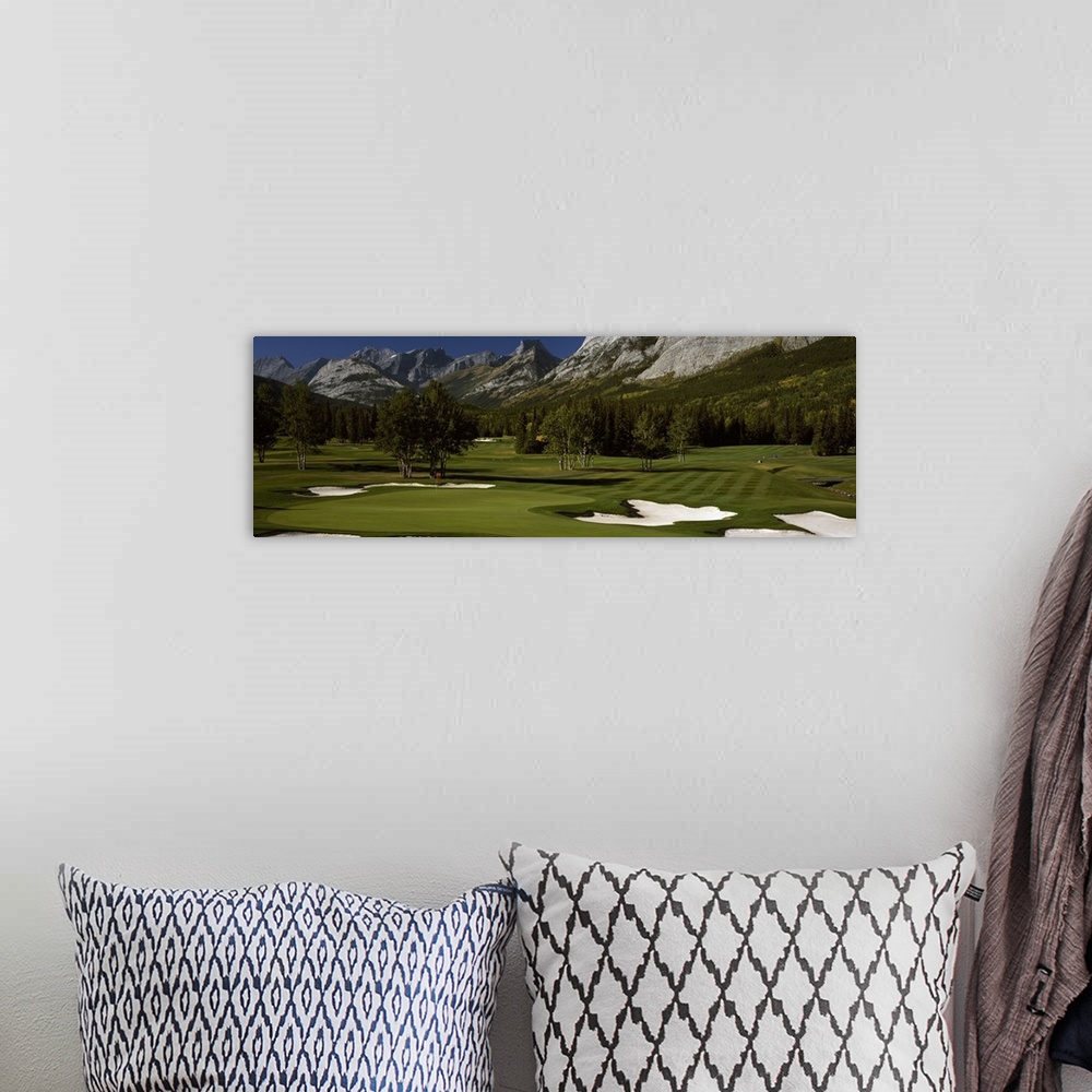 A bohemian room featuring Panoramic photograph taken on a golf course of one of the holes that is surrounded by a mountain ...