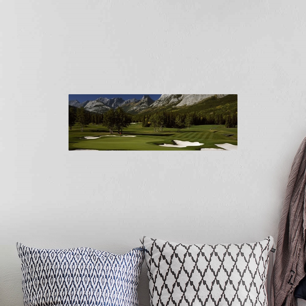 A bohemian room featuring Panoramic photograph taken on a golf course of one of the holes that is surrounded by a mountain ...