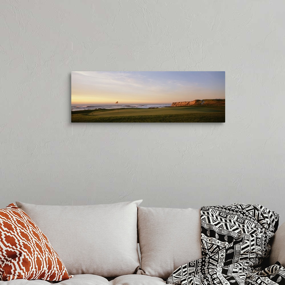 A bohemian room featuring Panoramic photograph on a large canvas of the green on a golf course, along the coast of Half Moo...