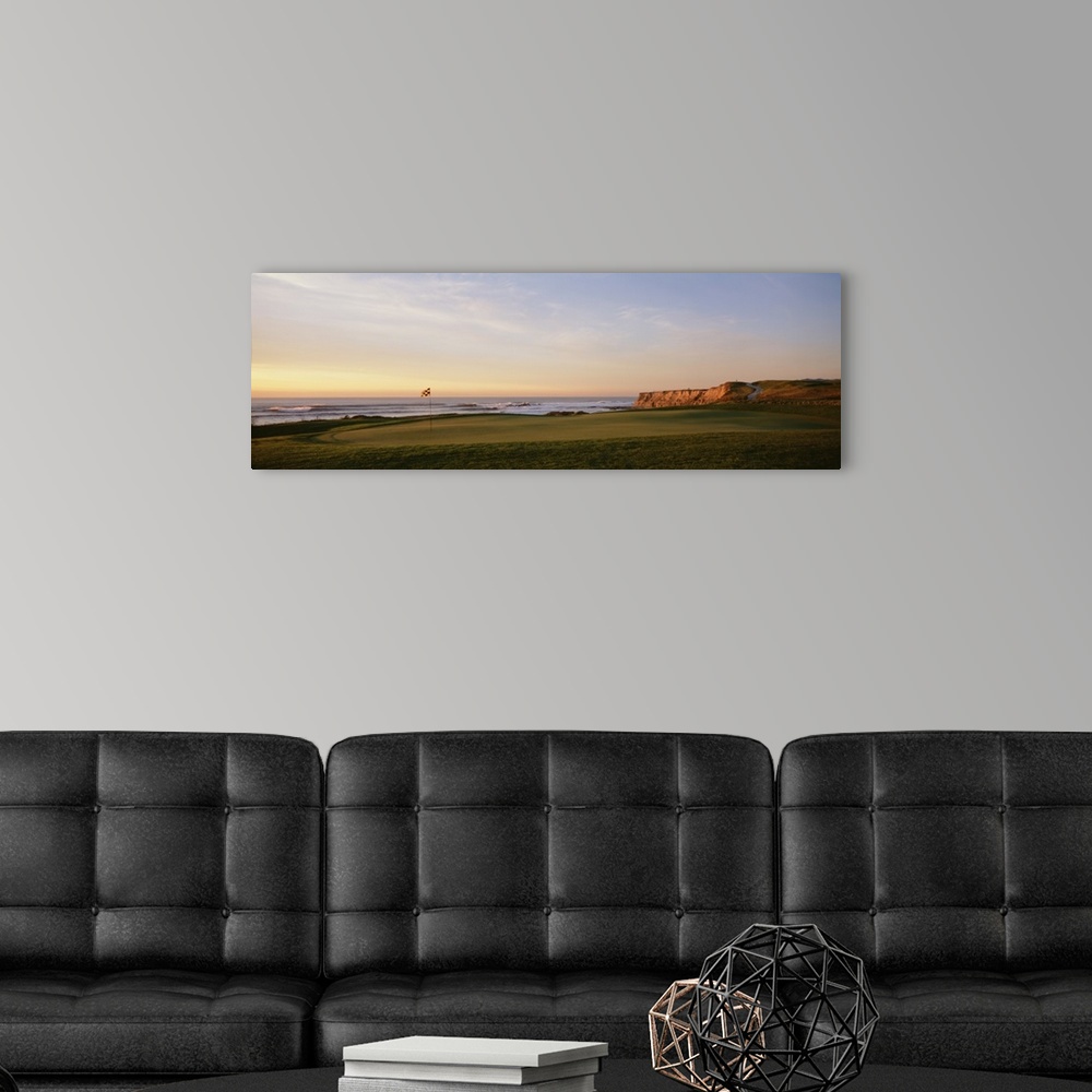 A modern room featuring Panoramic photograph on a large canvas of the green on a golf course, along the coast of Half Moo...