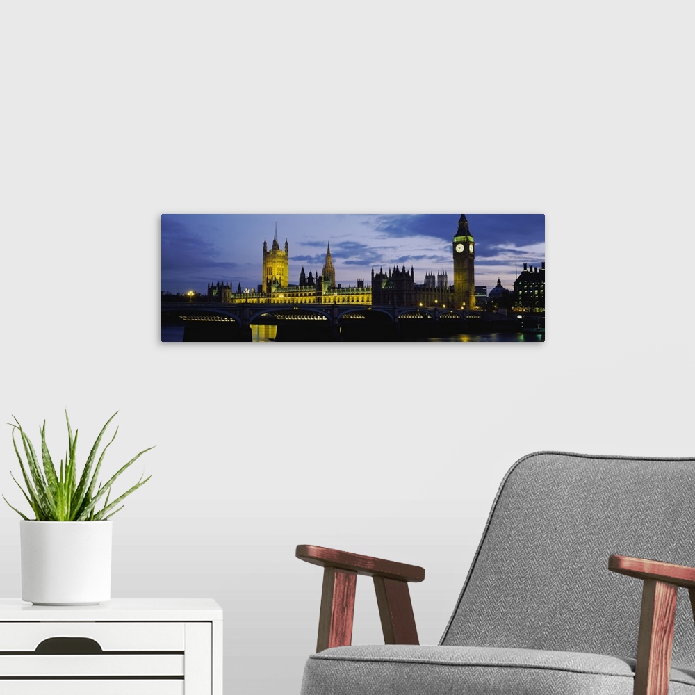 A modern room featuring London Skyline at dusk Thames river in foreground also pictured Big Ben, Halls of Parliament.