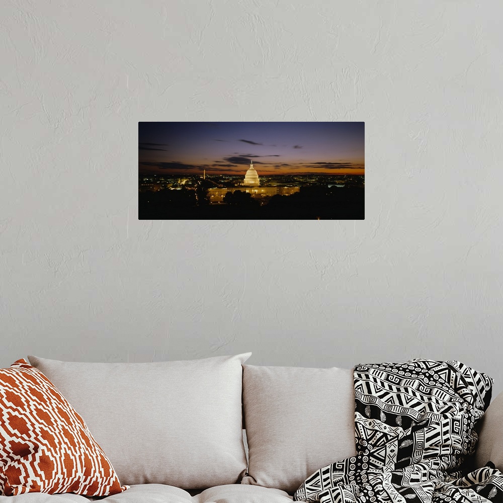 A bohemian room featuring An aerial shot taken at a distance of the capitol building illuminated under a sunset sky.