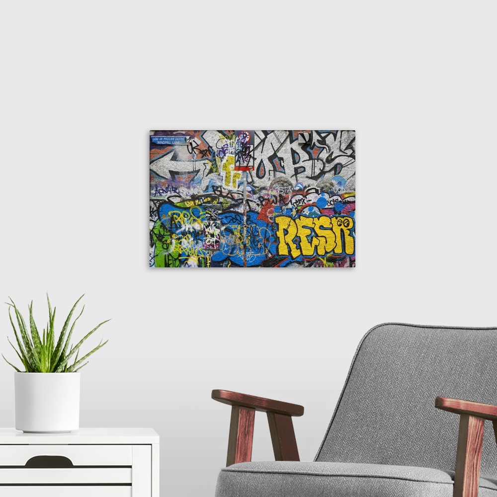 A modern room featuring Large photograph of colorful grafitti on the U2 Wall on Windmill Lane in Dublin, Ireland. Crowded...