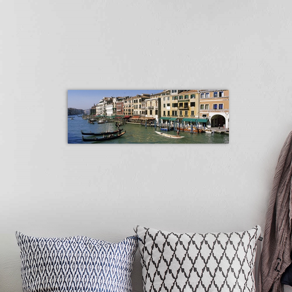 A bohemian room featuring Large panoramic of a busy canal in Venice, Italy with gondola's and boats floating on the water a...
