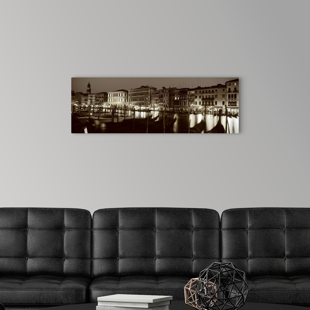 A modern room featuring Panoramic photograph of the Grand Canal in Venica, Italy. A line of gondola boats are tied to a d...
