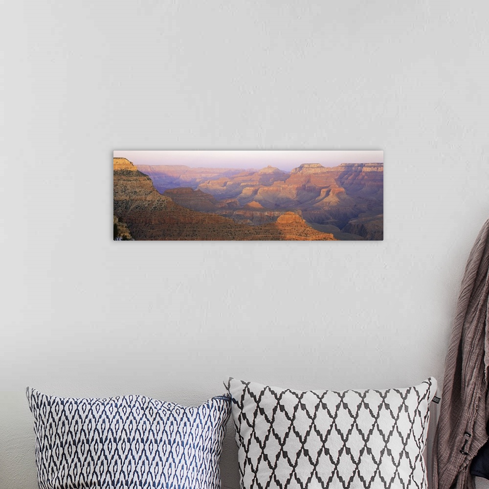 A bohemian room featuring Panoramic photograph of sand colored gorge under a foggy sky.