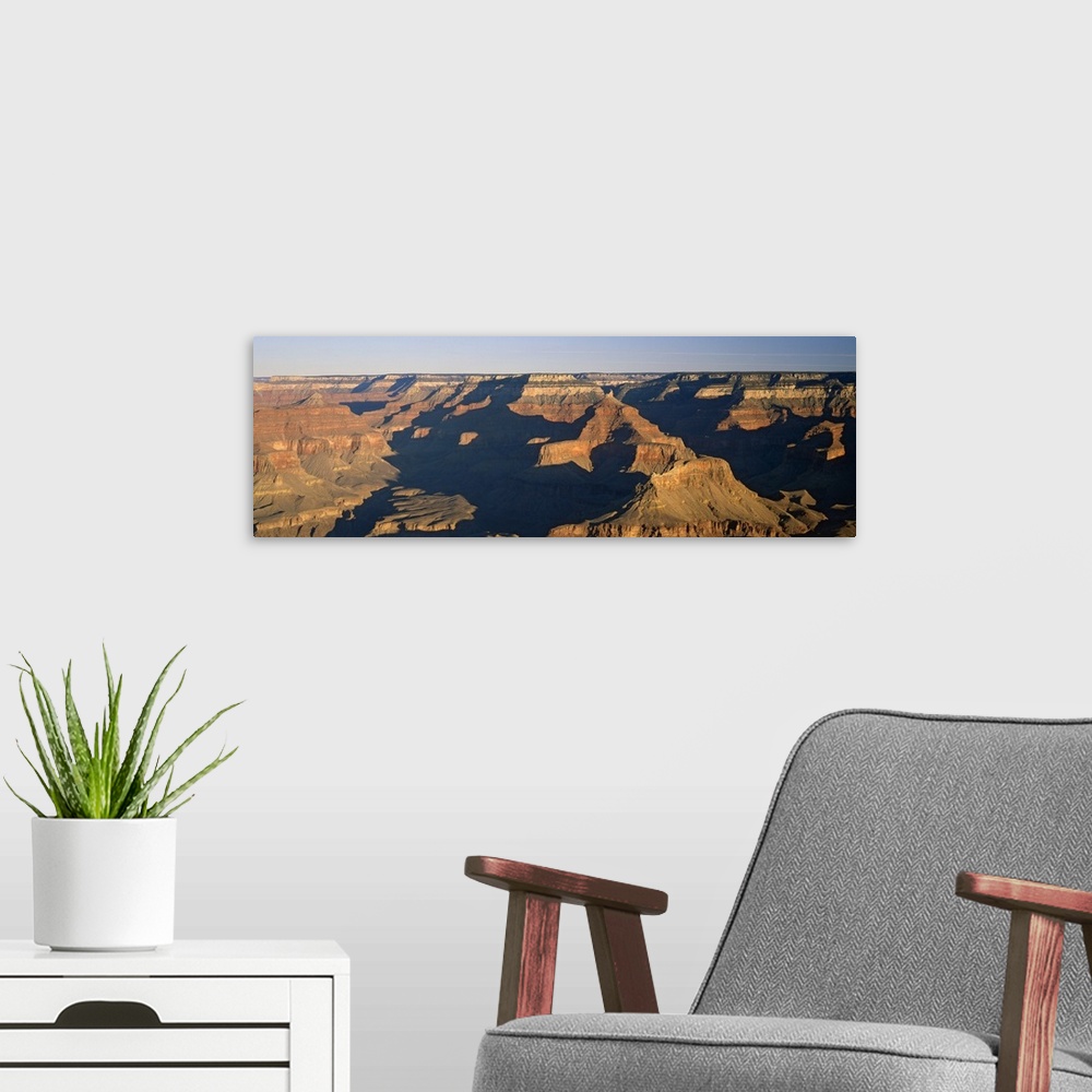 A modern room featuring Panoramic photograph of the large rock formations of the Grand Canyon in the golden sunlight, in ...
