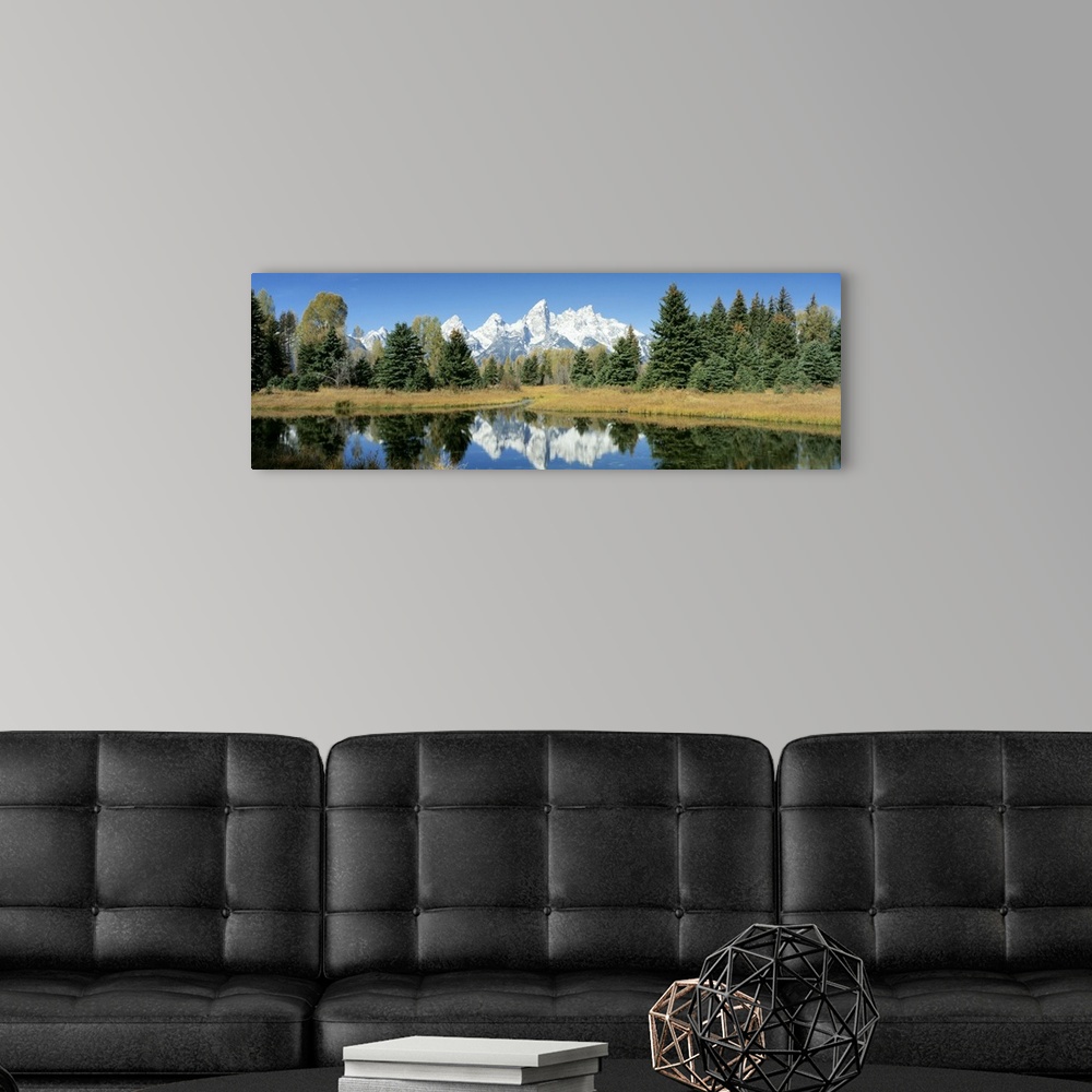 A modern room featuring This panoramic shot is perfect for the home or office of a national park with a body of water in ...
