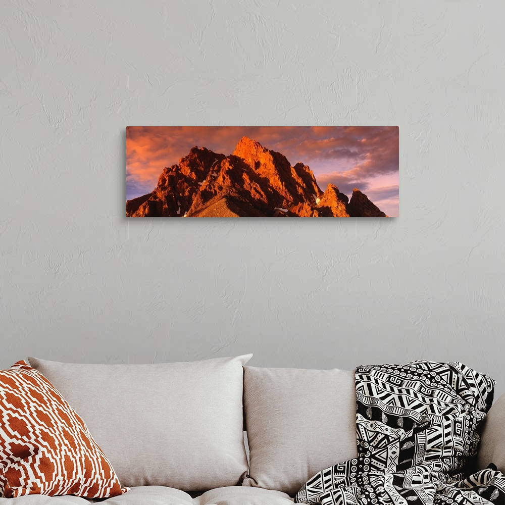 A bohemian room featuring Panoramic photograph of huge rock formation under a cloudy sky at dusk.