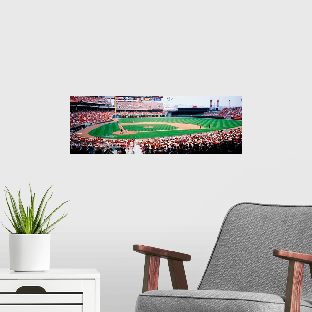 A modern room featuring A crowded baseball stadium photograph from near home plate on a panoramic canvas.